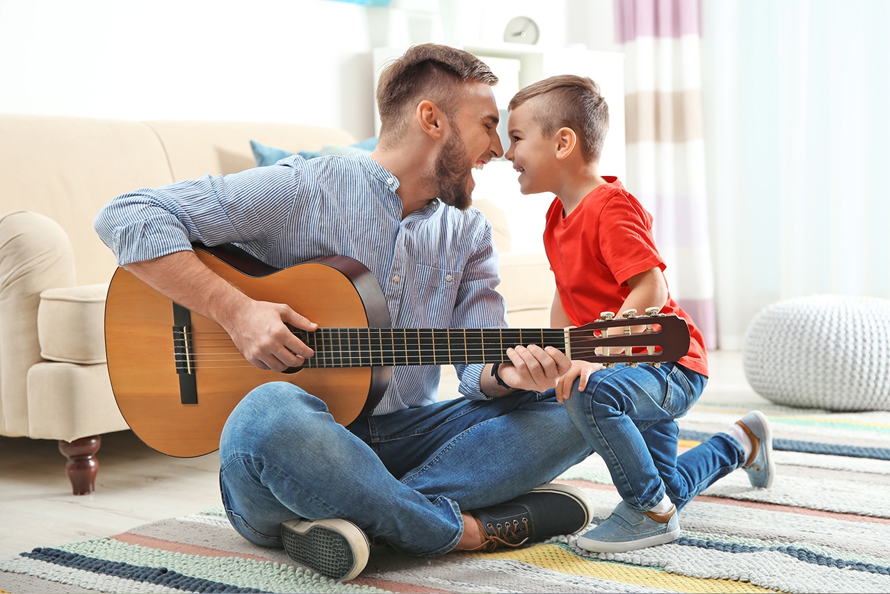 doing the things you love – a dad playing guitar and spending time with his son.